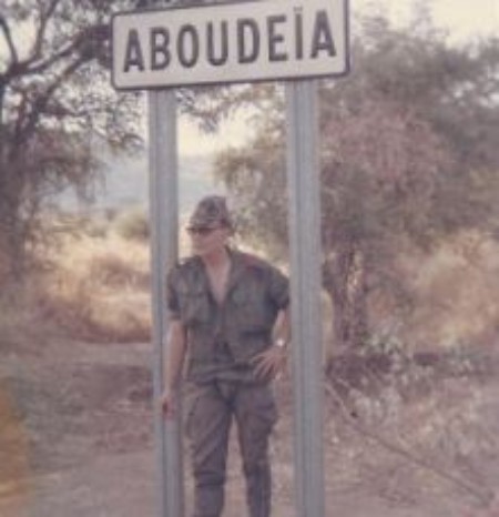 Alain SOLER sous le panneau indicateur  ABOU - DEIA  Petite localité Tchadienne (dans la province du  SALAMAT )